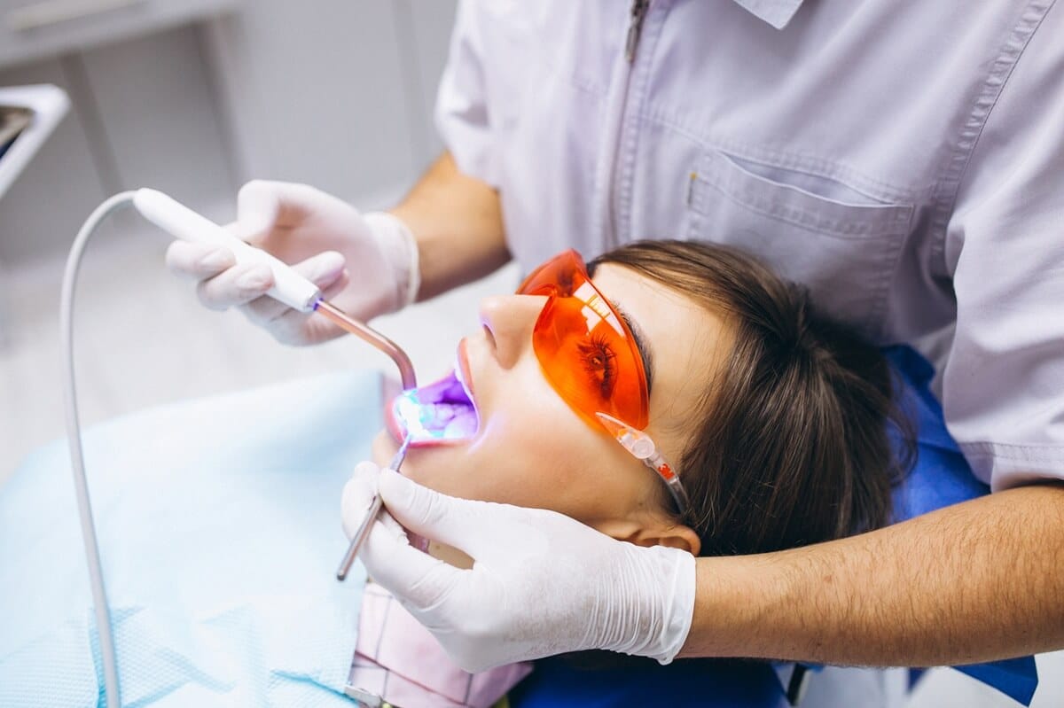 Biostymulacja laserowa - pacjentka w gabinecie stomatologicznym w trakcie zabiegu laserowego